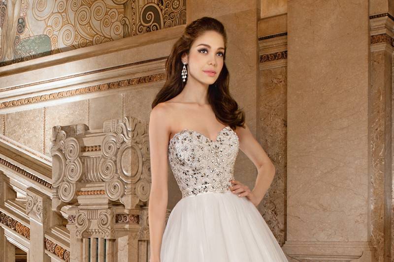 566This elegant, tulle, ball gown features a soft sweetheart neckline with beaded flower embroidery accented with delicate crystals. The lace-up back is finished with a chapel train.