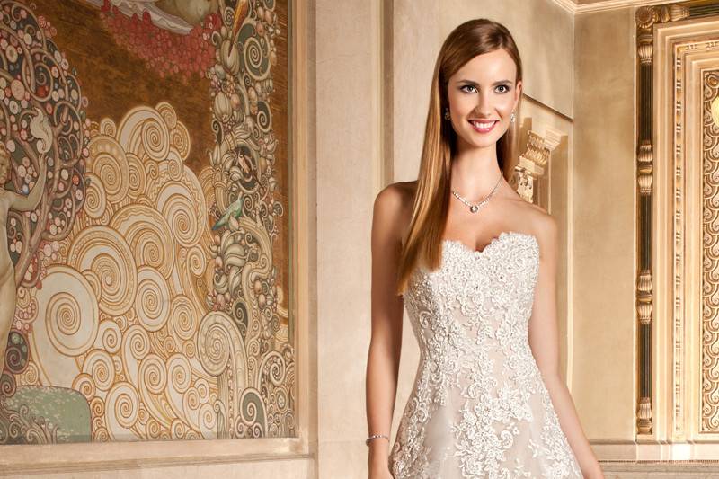 1494This magnificent a-line gown is richly embellished with beaded alencon lace and features a sweetheart neckline and sculpted straps that flow into a low sheer back with button closure. Back is finished with a striking chapel train.