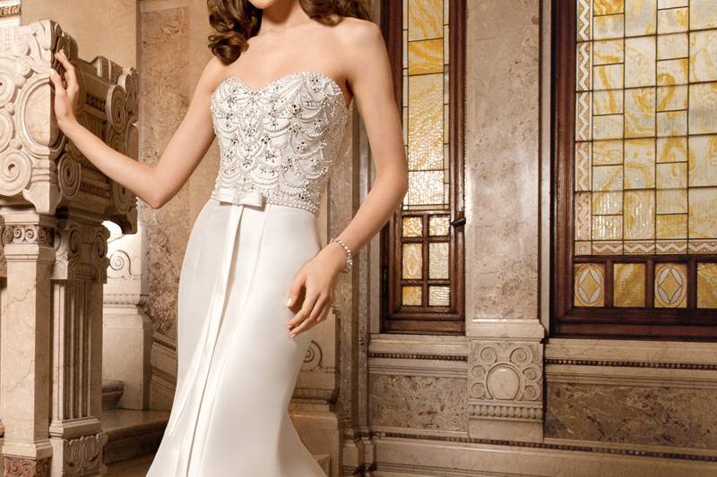 3211Elegant, strapless, form fitting, mikado gown with sweetheart neckline and beaded pearl embroidery with jewel accents on bodice. Waist is finished with beaded trim and bow. The back features a button closure.