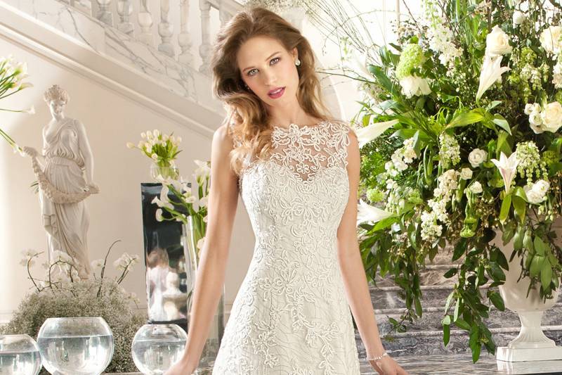 212This timeless, a-line, gown features delicate embroidered lace with a sweetheart silhouette and illusion lace overly creating a bateau neckline. The illusion lace back features a button closure.