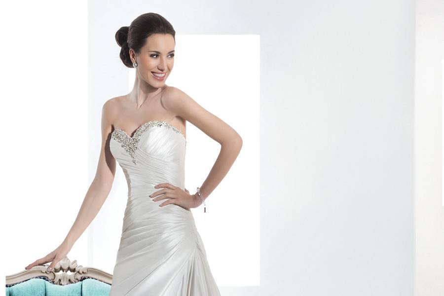 3208Taffeta, Strapless, A-line wedding gown with a beaded Sweetheart neckline, wrapped bodice with asymmetrical pleating and lace-up back. The skirt on this bridal dress features a wrapped side split and Chapel length train.