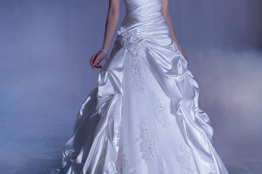 4315Satin, A-line wedding gown with a beaded lace bodice featuring a Sweetheart neckline cap sleeves and high lace keyhole back. This bridal dress also features a pleated wrap waist and split bustled skirt with tulle and lace underlay. Back is finished with buttons and attached bustled skirt.