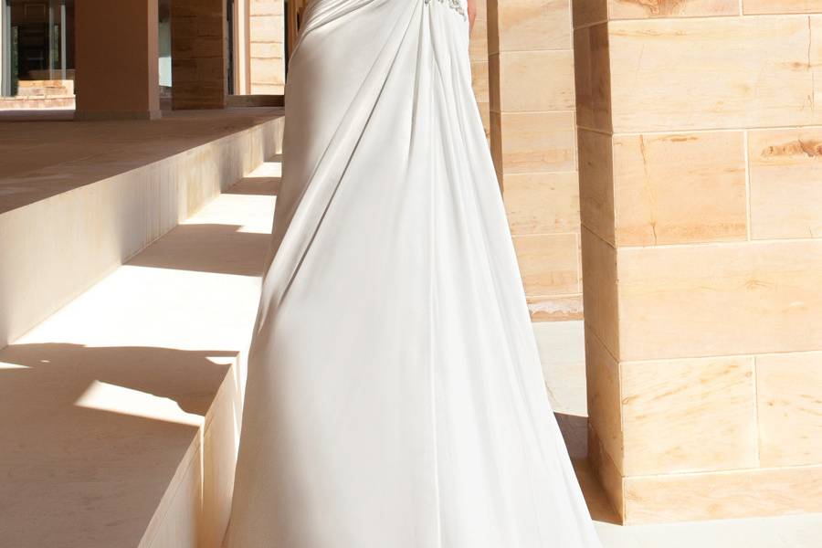 189Chiffon, One-shoulder destination wedding gown with asymmetrical wrapped ruching and beaded motif on bodice. The A-line skirt on this bridal dress features a Sweep train.