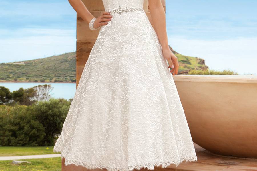 192Chantilly lace, Strapless, A-line, Cocktail length destination wedding dress with jeweled trim on waist. This bridal dress features a scalloped neckline and hem.