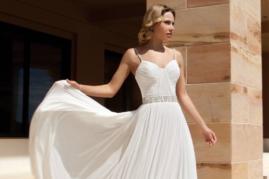 205Chiffon, A-line destination wedding gown with spaghetti straps, asymmetrical ruching on bodice and beaded band on waist. The skirt on this bridal dress features a Chapel train.