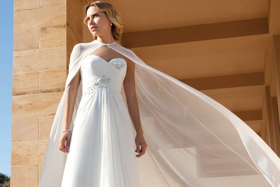 207Chiffon, Strapless, Sweetheart neck, A-line destination wedding gown with a ruched, Empire bodice and 3 dimensional beading. This bridal dress features a chiffon cape and Chapel length train.