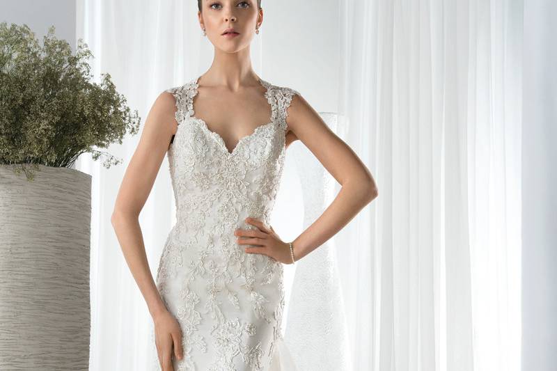 Style 617 <br> This sophisticated Fit-N-Flare beaded lace gown features a V-neckline with lace straps that transition into a dramatic plunging illusion back. With a removable lace Chapel train with a scalloped edge.