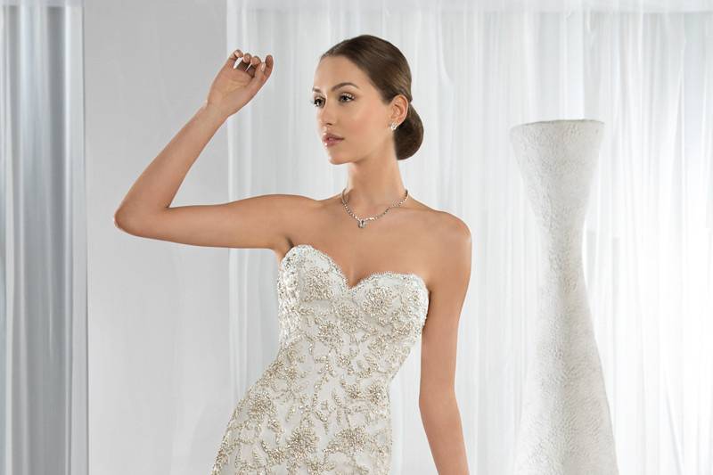 Style 621 <br> This glamorous form fitting Fit-N-Flare gown features intricate beaded lace and a sweetheart neckline. The back transitions into a Chapel length train and lace-up closure.