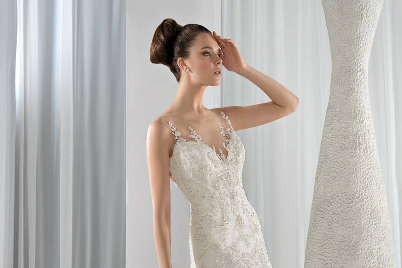 Style 629 <br> This classic A –line lace gown features a high illusion neckline with intricate beading that transitions into a dramatic low illusion back with a Chapel train.