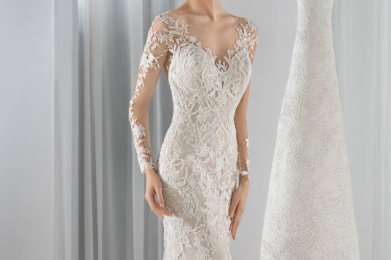 Style 635 <br> This Chic lace Sheath gown features a high sheer neckline and long sleeves with appliques of lace. The low sheer back is embellished with button closure and a Chapel train.