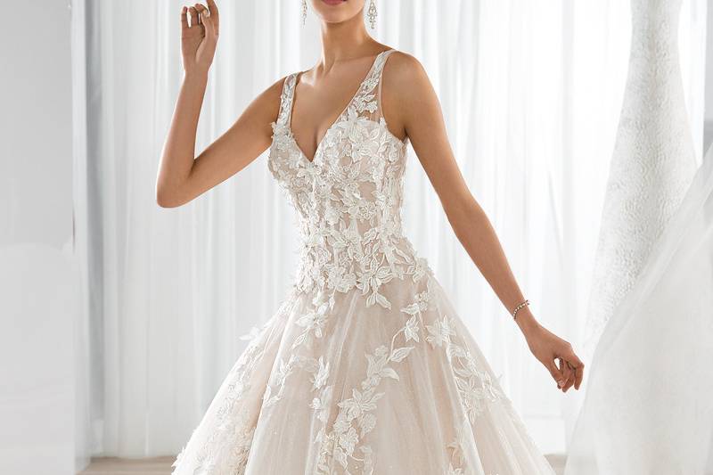 Style 640 <br> This classic Ball Gown features a V- neckline with a shimmering tulle skirt and romantic lace appliques. The sheer straps transition to an open V back and Chapel train.