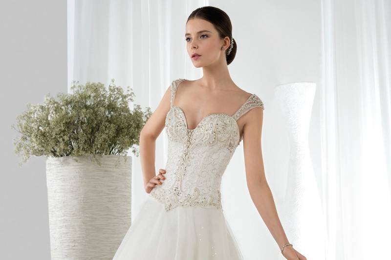 Style 642 <br> This sparkling Ball Gown is embellished with a beaded bodice with a sweetheart neckline and Basque waist. The back features lace-closure and a Chapel train.