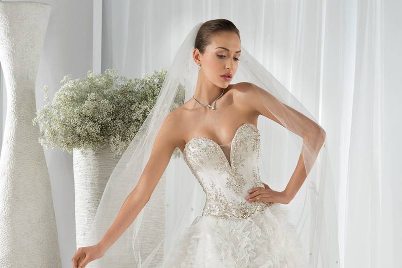 Style 649 <br> This magnificent beaded tulle Ball Gown is embellished with a sweetheart neckline beaded bodice and Basque waist. The back features lace- up closures and a Chapel length train.