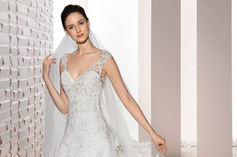Style 731 <br>  This classic A-line gown with Sweetheart neckline features sheer lace cap sleeves that flow into a striking low illusion back with lace accents and lace embellished Cathedral train.