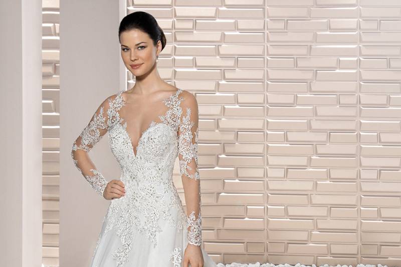 Style 727 <br>	The barely there illusion and lace sleeves and back add contemporary drama to this classic Lace A-line gown with plunging Sweetheart neckline and Chapel length train.