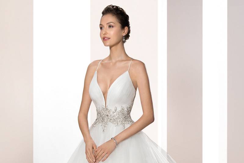 Style 725 <br>	This striking Tulle Ball gown with spaghetti straps and plunging V-neckline is embellished with sparkling beaded embroidery on the waist and features a Chapel length train.