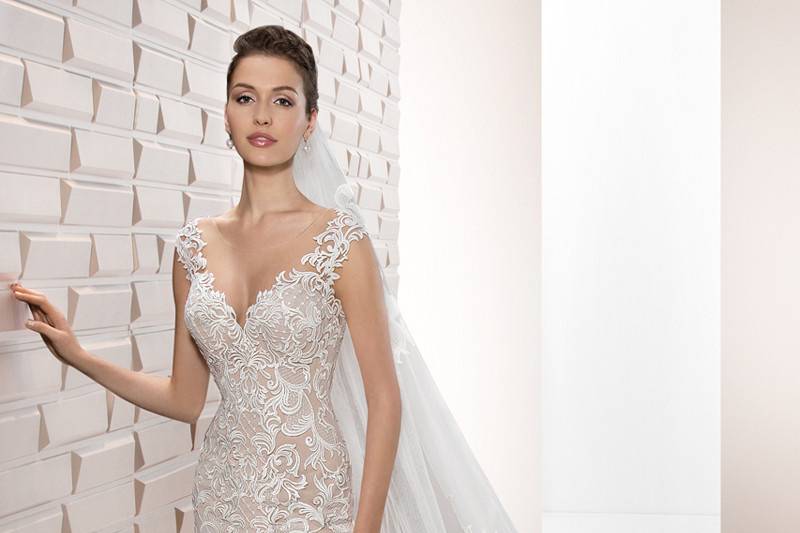 Style 714 <br>	This romantic lace over tulle sheath gown with Sweep train features a Sweetheart neckline and delicate lace embroidery on the shoulders flowing into a stunning sheer back adorned with lace embroidery and button closure.