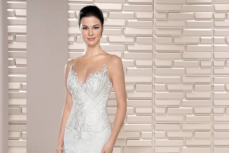 Style 710 <br>	This unique embroidered Venice lace fit n flare gown features a barely there sheer neckline over a Sweetheart silhouette and artfully embroidered lace over sheer illusion back.