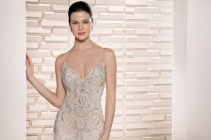 Style 695 <br>	Bugle beads, pearls and crystals embellish this sultry Tulle sheath with V-neckline, Spaghetti straps and plunging low back.  A striking Chapel train completes the look.