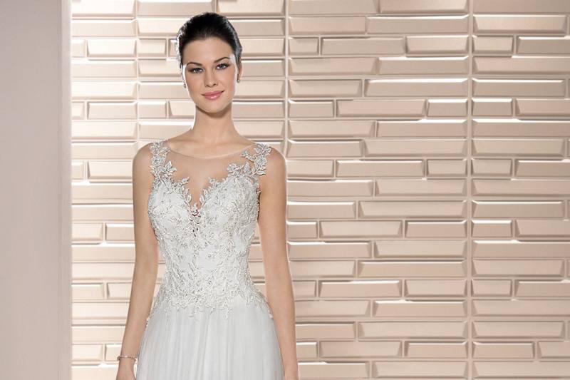 Style 684 <br>	This understated, elegant gown with dropped waist and soft Sweetheart neckline accented with crystal beading combines embroidered lace appliques with a flared tulle skirt finished with a Sweep train.