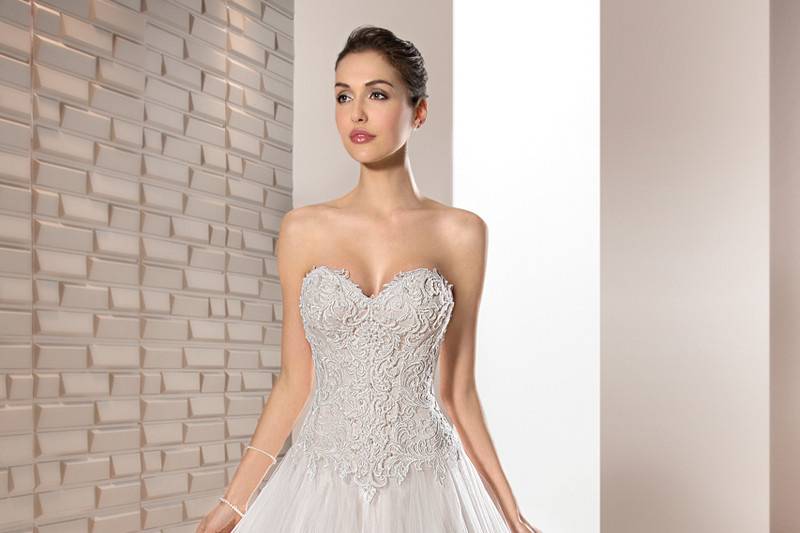 Style 664 <br>	Delicately beaded Venice lace adorns the bodice of this elegant Tulle Ball gown featuring a Sweetheart neckline and Basque waist.  The back is finished with a Lace-up closure and Chapel length train.