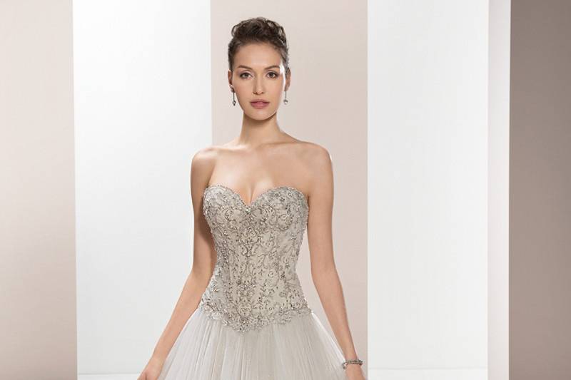 Style 657 <br>	This shimmering Tulle Ball gown with Sweetheart neckline features magnificent crystal beading on the bodice and Basque waist.  The back is finished with a lace-up closure and Chapel train.