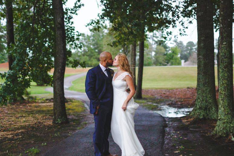 Newlyweds kiss by the winding road