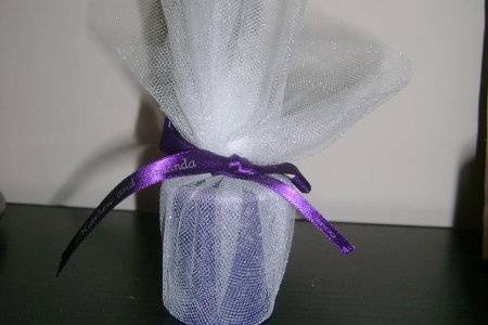 Votive candle wrapped in tulle with a ribbon that has the name of the bride and groom along with the date.