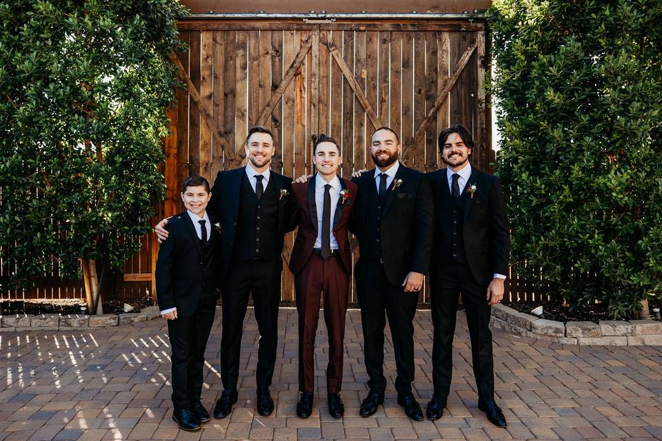 Groomsmen in front of barn doo