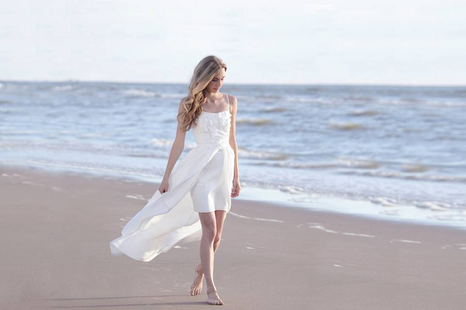 After you have elegantly opened your ceremony in a floor-length number, surprise your wedding party at night when you sweep the dancefloor in your mini dress.
The light silk skirt feels luxurious on your skin and has a noble, soft luster. Folds create controlled volume