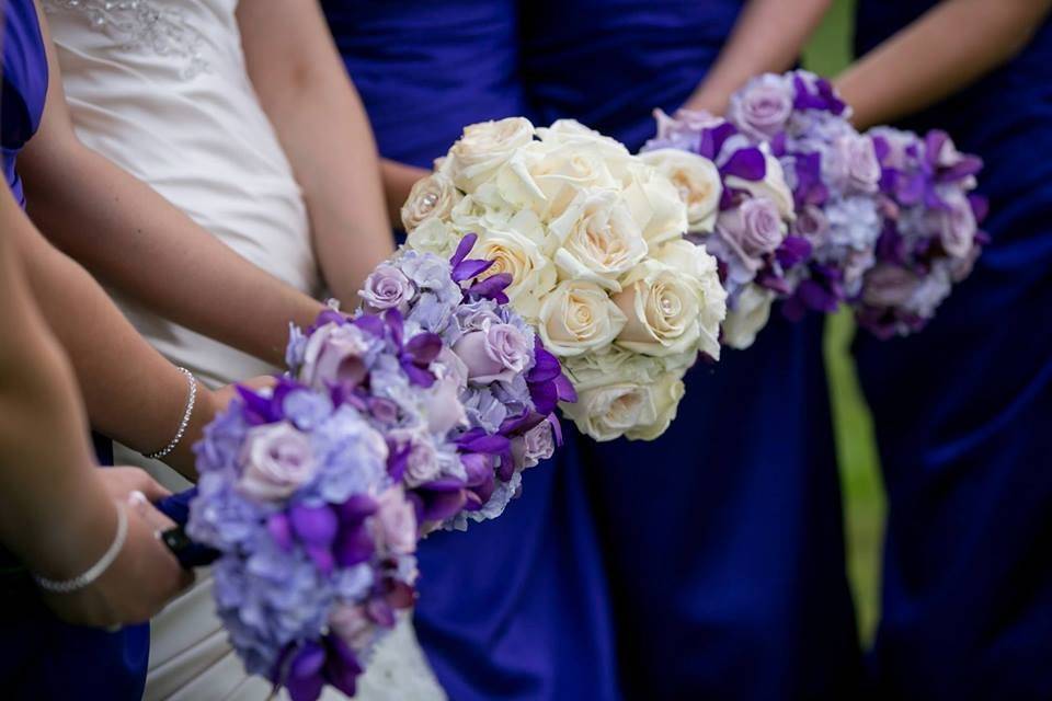 White bridal bouquet and purple bridesmaid bouquets