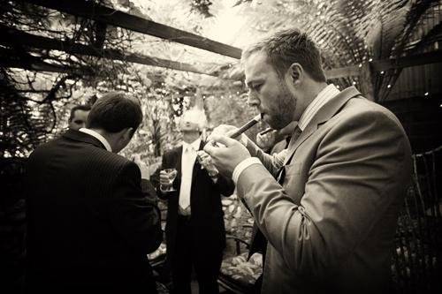 Gentlemen enjoying cigars and port at a Holly Farm reception.