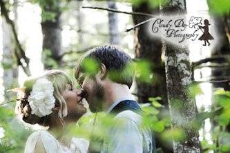 A kiss shared in the depths of the forest in this vertically oriented wedding photo, taken just after the ceremony outside of Corvallis, Oregon.