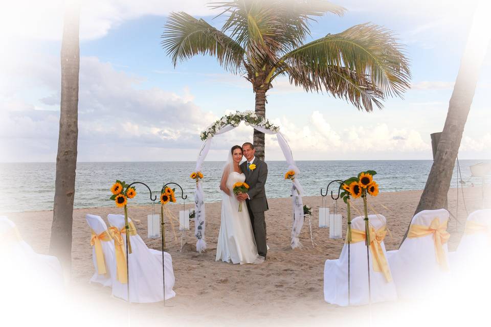 Sunflower theme on arch & shephard hooks with lanterns on beach across from Casablanca Cafe Ft.Laud.