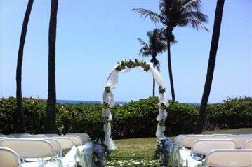 Ivory arch with aisle pedestals and tulle swagged along aisle.