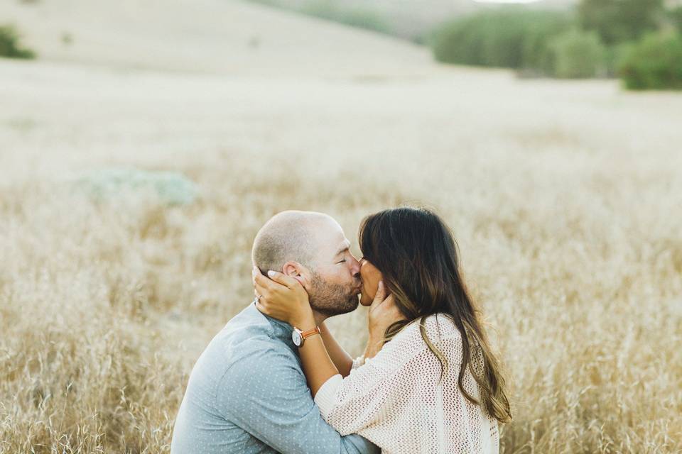 Couple kissing in the field - Burlap + Blossom Photography