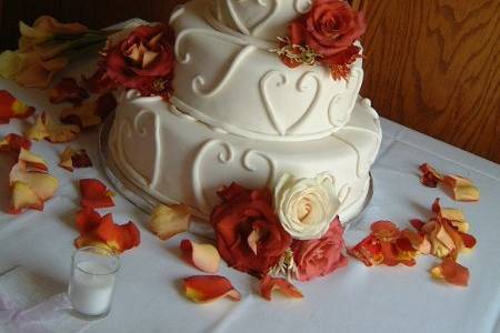 Fondant covered with fondant heart details and fresh flowers.