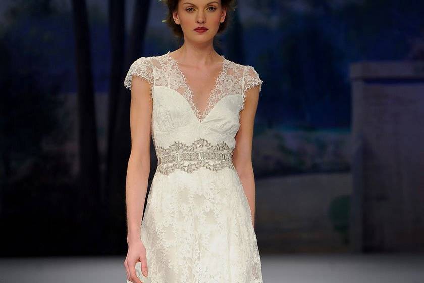 BRIGITTE <br>Silk white cap sleeved V-neck lace gown with silver guipure belt over full lace skirt lined in pearl silk.