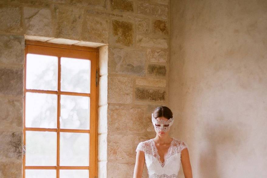 BRIGITTE <br>Silk white cap sleeved V-neck lace gown with silver guipure belt over full lace skirt lined in pearl silk.