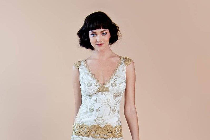 DEAUVILLE <br>Gold embroidery on fine ivory tulle over a sumptuous pearl silk charmeuse wedding dress accented with gold guipure embellished drop waist, shoulders and neckline.
