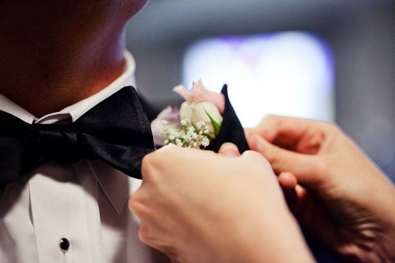 Groom corsage being pinned to suit