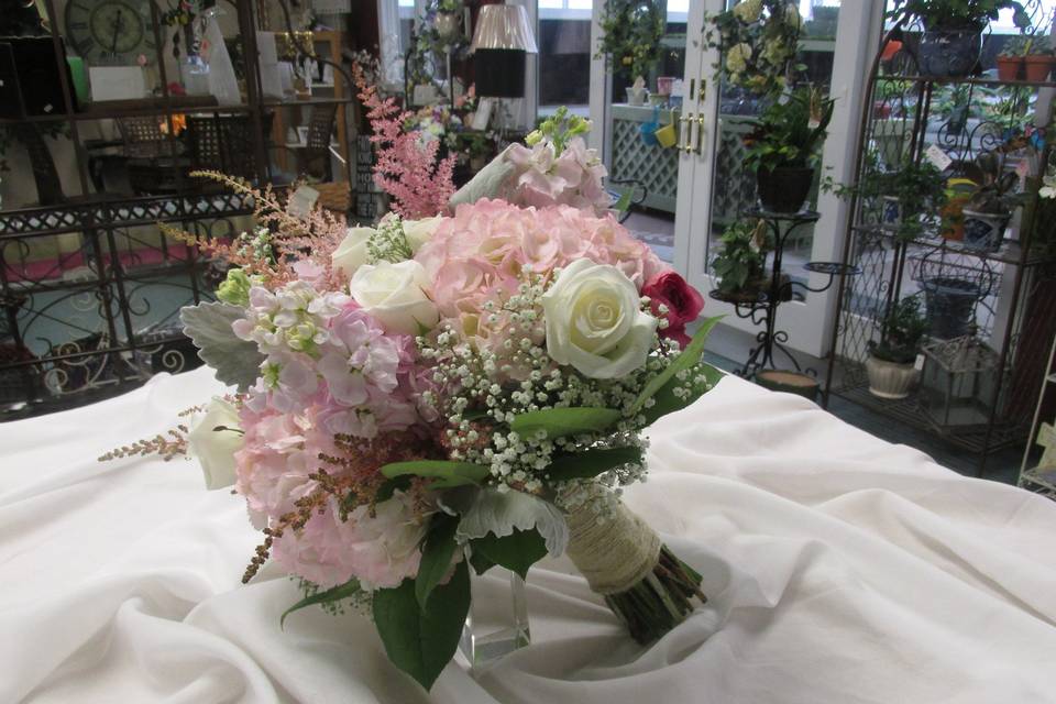 This lovely bridal bouquet consists of pink hydrangea and stock, white roses and babies breath and accents of pink astilbe and dusty miller.