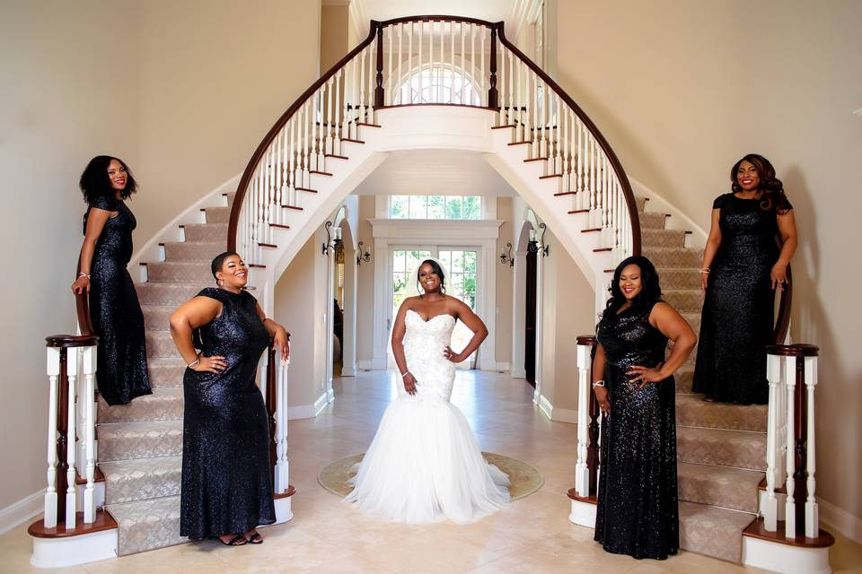 Bride and her bridesmaids posing by the staircase