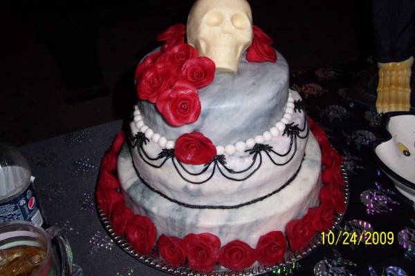 Red Velvet cake with Raspberry sour cream filling.  All decor handmade of fondant.  Skull of white chocolate.  The filling was soft enough that it bled when the cake was cut