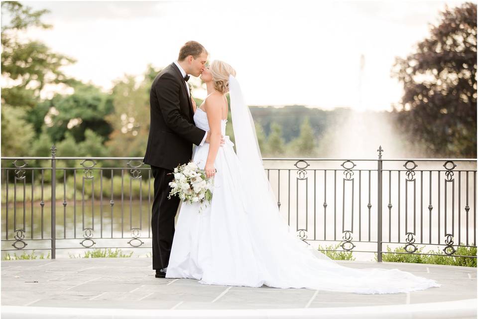 Newlyweds kiss by the water