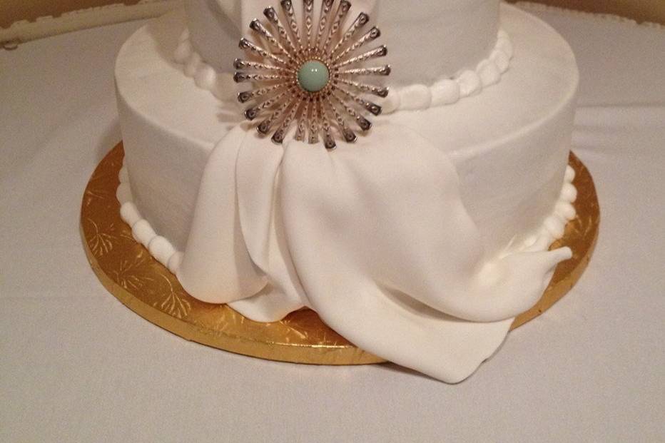 Buttercream frosted cake with fondant swag - $2.50 per serving ($2.75 for 5+ tiers)