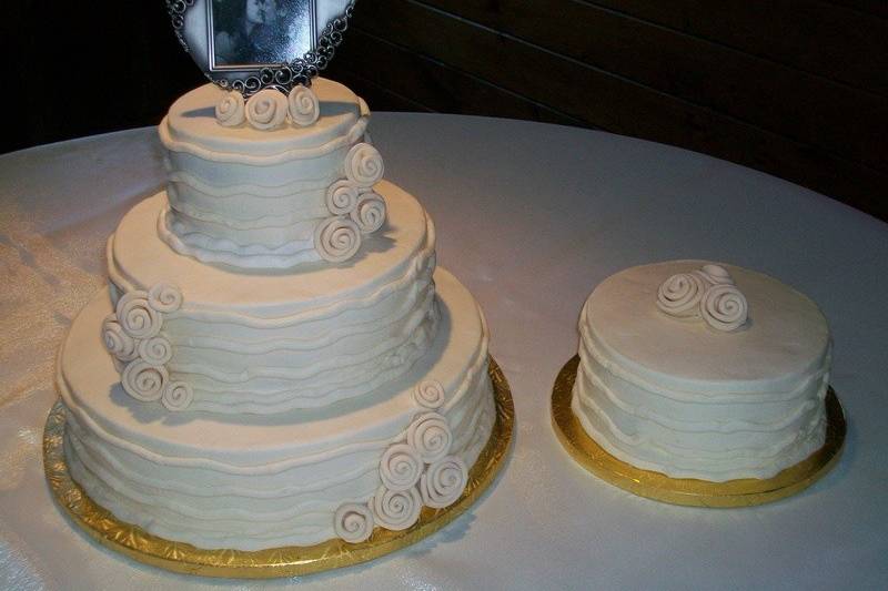 Buttercream frosted cake with fondant accents - $2.50 per serving ($2.75 for 5+ tiers)
