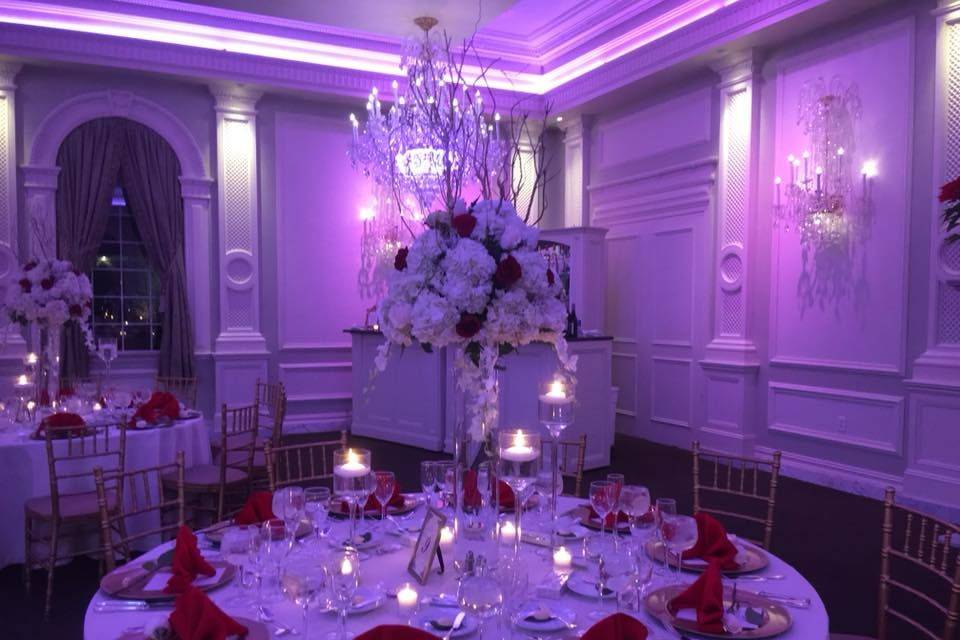 Pink uplights and candlelit table setup