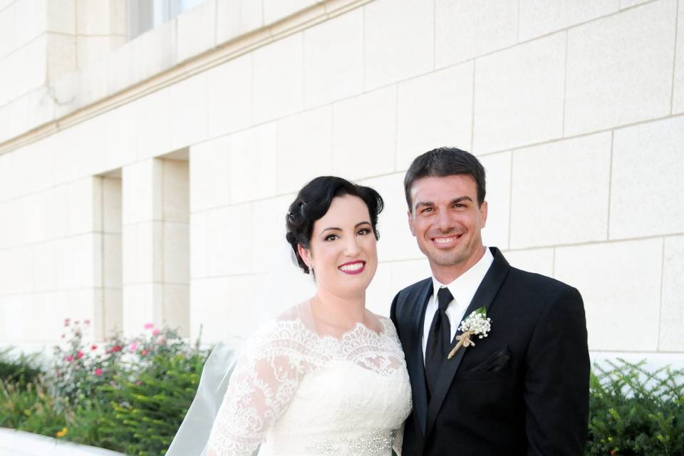 Couple standing in front of greenery