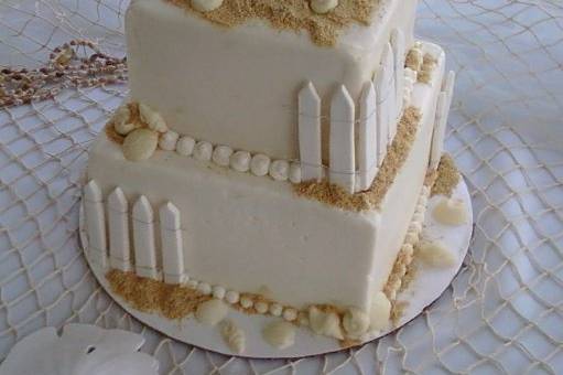 Beach Wedding Cake with gumpaste fencing, white chocolate shells and keepsake beach chairs.